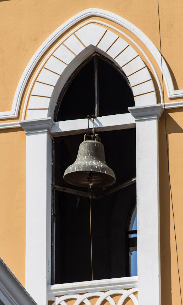 gallery-01 A sunlit bell hanging in a classic arched window in Granada, Nicaragua.