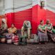 Crafting Captivating Headlines: Your awesome post title goes here Elderly vendors sitting by a store, selling goods in an urban street setting.